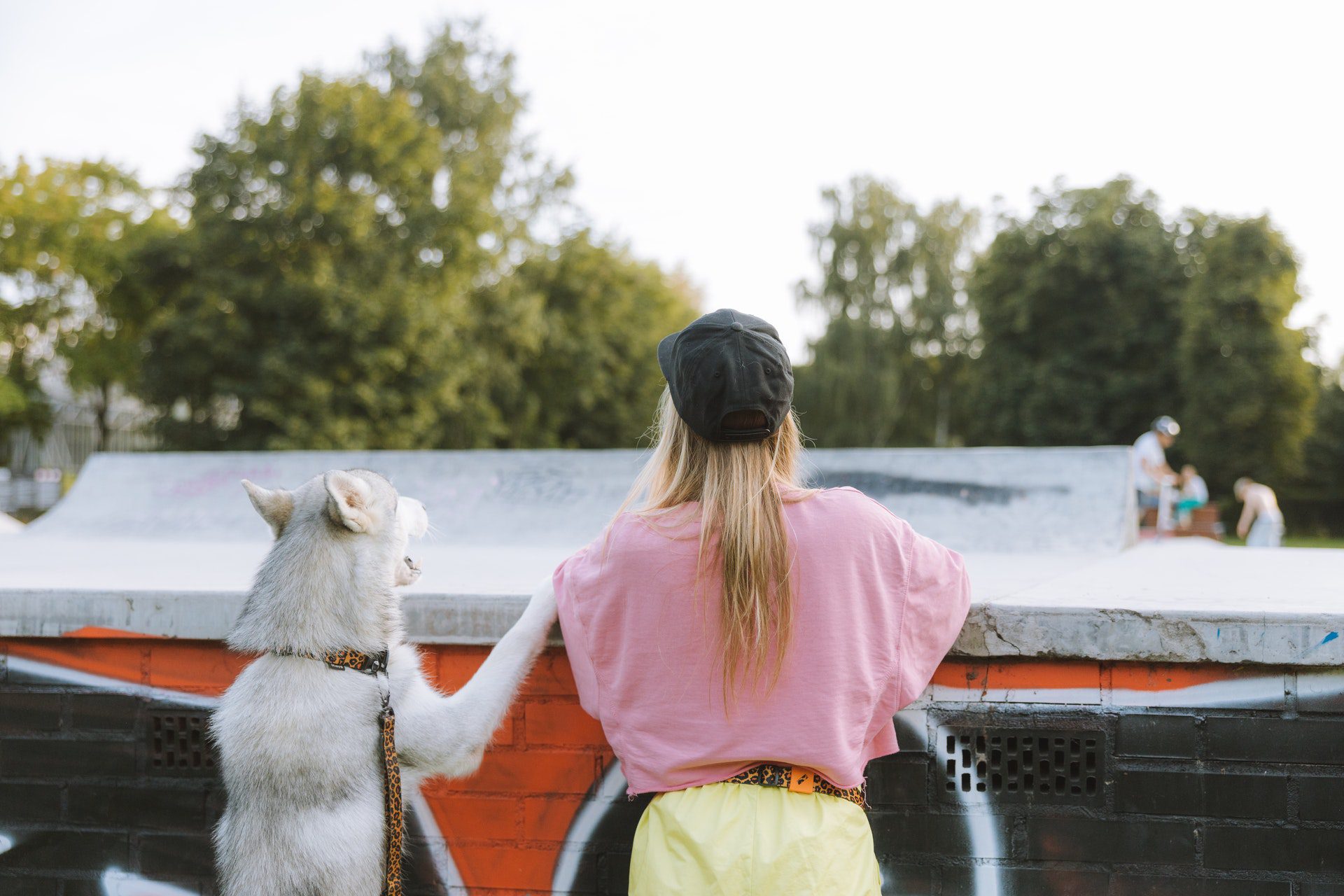 Photo of a woman and dog standing at a wall